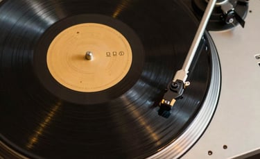 A stylish overhead shot of a vinyl record spinning on a high-end turntable with gold metallic details and dark base.
