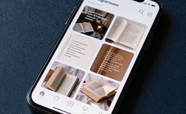 A close-up of a smartphone screen showing a stylishly curated Instagram feed of poetry and books, resting on a dark blue textured surface.