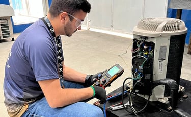An HVAC technician uses a digital manifold gauge to perform AC repair on an outdoor condenser unit.