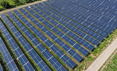 Aerial view of a large solar panel farm installation providing renewable energy in a rural landscape.