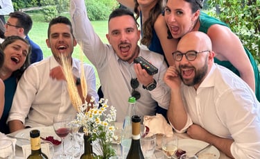 a group of people sitting at a table with wine glasses and wine bottles