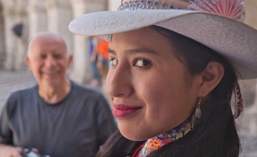 This image shows a woman wearing an embellished hat with colorful beadwork and a pink fan, likely of Peruvian origin.
