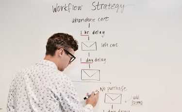 man writing process flow on whiteboard