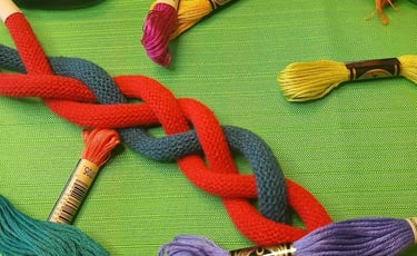 a bunch of thread - wrapped thread threads and scissors