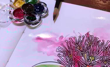 Close up of Pōhutukawa colouring book page, painted with watercolour paint which is still wet