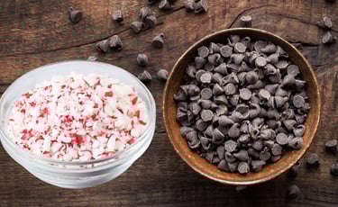 a bowl of chocolate chips and a bowl of candy cane