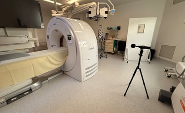 Un scanner CT Canon moderne dans une salle d'imagerie médicale lumineuse avec un sonomètre trépied.