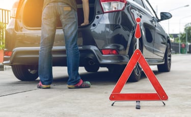 a man standing in front of a broke down car