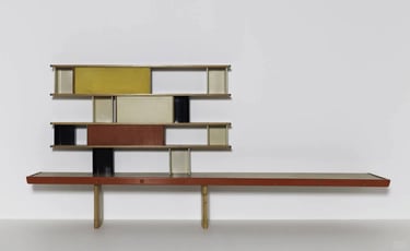 Modern modular wall shelf with wood and colored panels, reflecting Charlotte Perriand’s practical st