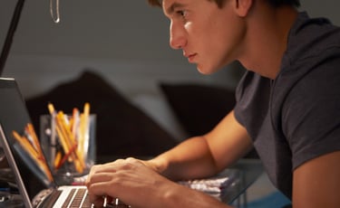 imagem mostra um jovem estudando com seu notbook. 