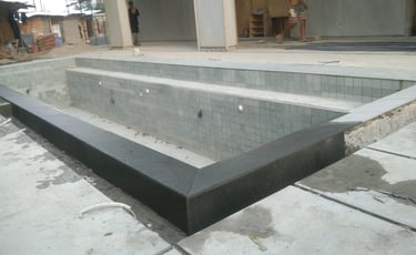 kolam renang beton dengan finishing batu alam.