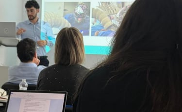 a group of people sitting at a table with laptops