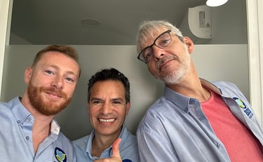 three men standing in a room with thumbs up