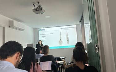 a woman in a white shirt is standing in front of a presentation