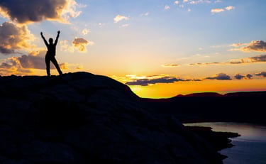 Hiker silhouette at dawn on Bear’s Hump overlooking Upper Waterton Lake.