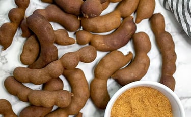 a bowl of tamarind powder and a bunch of tamarind
