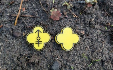 a pair of yellow and black flower shaped numbers on a dirt ground