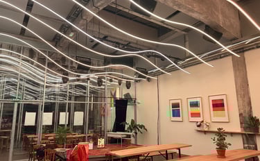 Intérieur de café industriel moderne avec plafonniers à bande LED incurvés et tables en bois