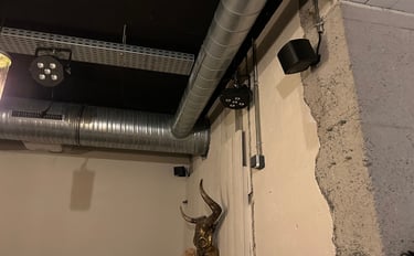 Plafond industriel avec conduits CVC exposés, éclairage de scène et décoration murale de crâne de t