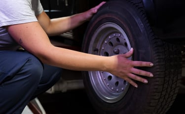 a person is holding a tire on a car