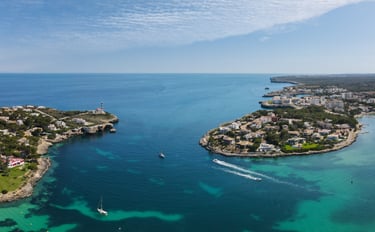 a boat sailing in the mediterranean sea near a Portcolom port