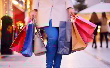 Woman with shopping bags walking down the street to symbolise AI in retail