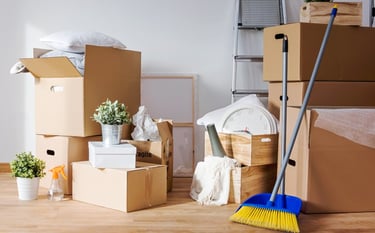 Boxes and cleaning supplies prepared for professional move-out cleaning in an empty home.