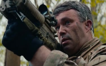 James Yeates Actor in a dramatic scene holding a prop weapon, showcasing action and military-style