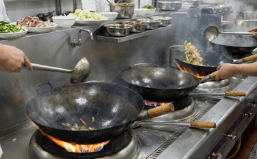 a person cooking in a kitchen with a lot of food,chinese cooking