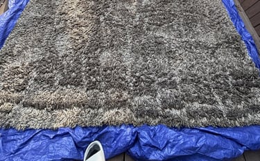 Gray rug on patio during deep cleaning. Outdoor rug cleaning for your convenience.