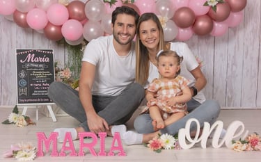 a man and woman sitting on a floor with balloons