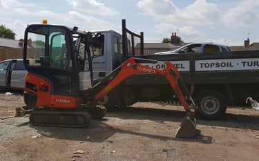 CMR digger in front of a pickup truck preparing for delivery in Dudley