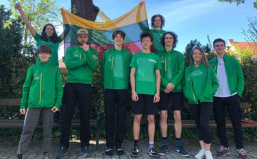 a group of people standing in front of a bench holding Lithuanian flag