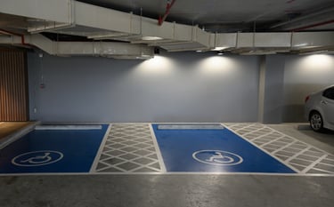 Plazas de minusválido de aparcamiento subterráneo, pintadas de color azul con líneas blancas