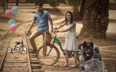 a man and woman standing next to a train track