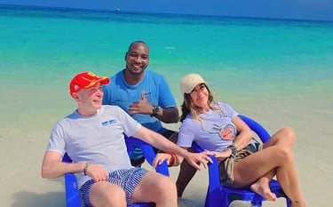 Couple enjoying a romantic day at Nakupenda Beach Sandbank, Zanzibar, with a friendly local tour guide by the clear blue wate