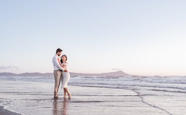 a man and woman standing in the ocean