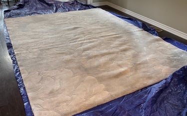 White rug on protective tarp: Professional in-home rug cleaning for ultimate convenience & safety.