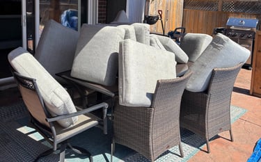 Outdoor patio cushions stacked for professional upholstery cleaning and drying in the sun.