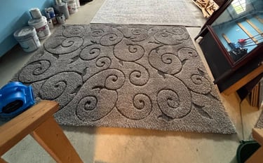 Two cleaned area rugs drying side-by-side in a garage.