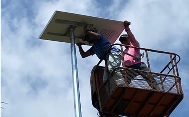 Technicians performing high-altitude electrical wiring on a solar panel.