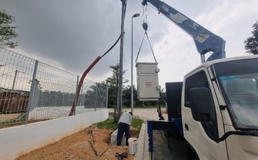 Installation of an electrical meter kiosk using a crane at a secured facility site, demonstrating professional electrical eng