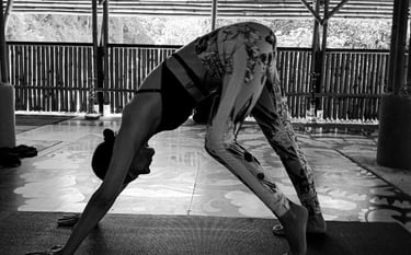 A woman transitions from Downward to Warrior One in Yoga practice