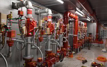 a bunch of red fire hydrant pipes and pipes