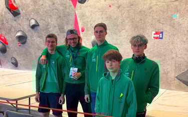 a group of people standing around a climbing wall