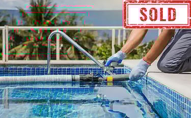 Person servicing a swimming pool with cleaning equipment, labeled "SOLD".