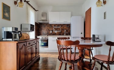 The photo shows the apartment's kitchen with a dining area.