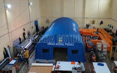 Dinas Sosial disaster relief site with blue emergency tents and workers providing humanitarian aid.