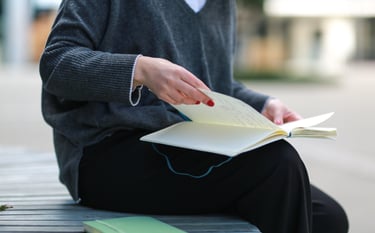 a woman sitting on a bench reading notes