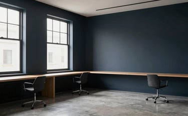 A wide shot of a minimalist, high-end design studio. Large windows let in natural light, hitting a dark navy accent wall. The space is uncluttered and sophisticated, representing high-quality agency work.
